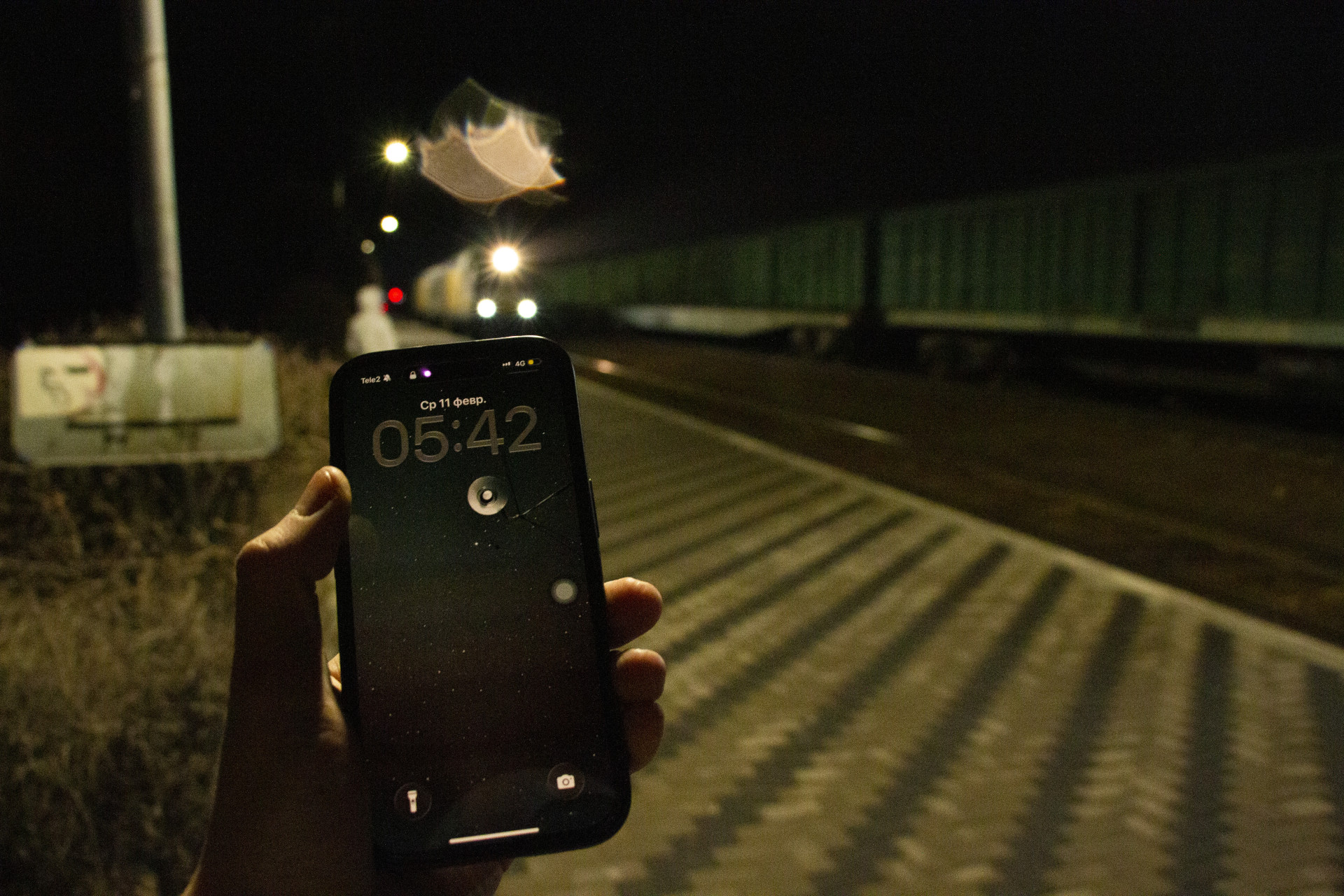 Телефон с часами - 05:42. На заднем фоне электричка наконец прибывает на станцию Капшагай (Конаев)