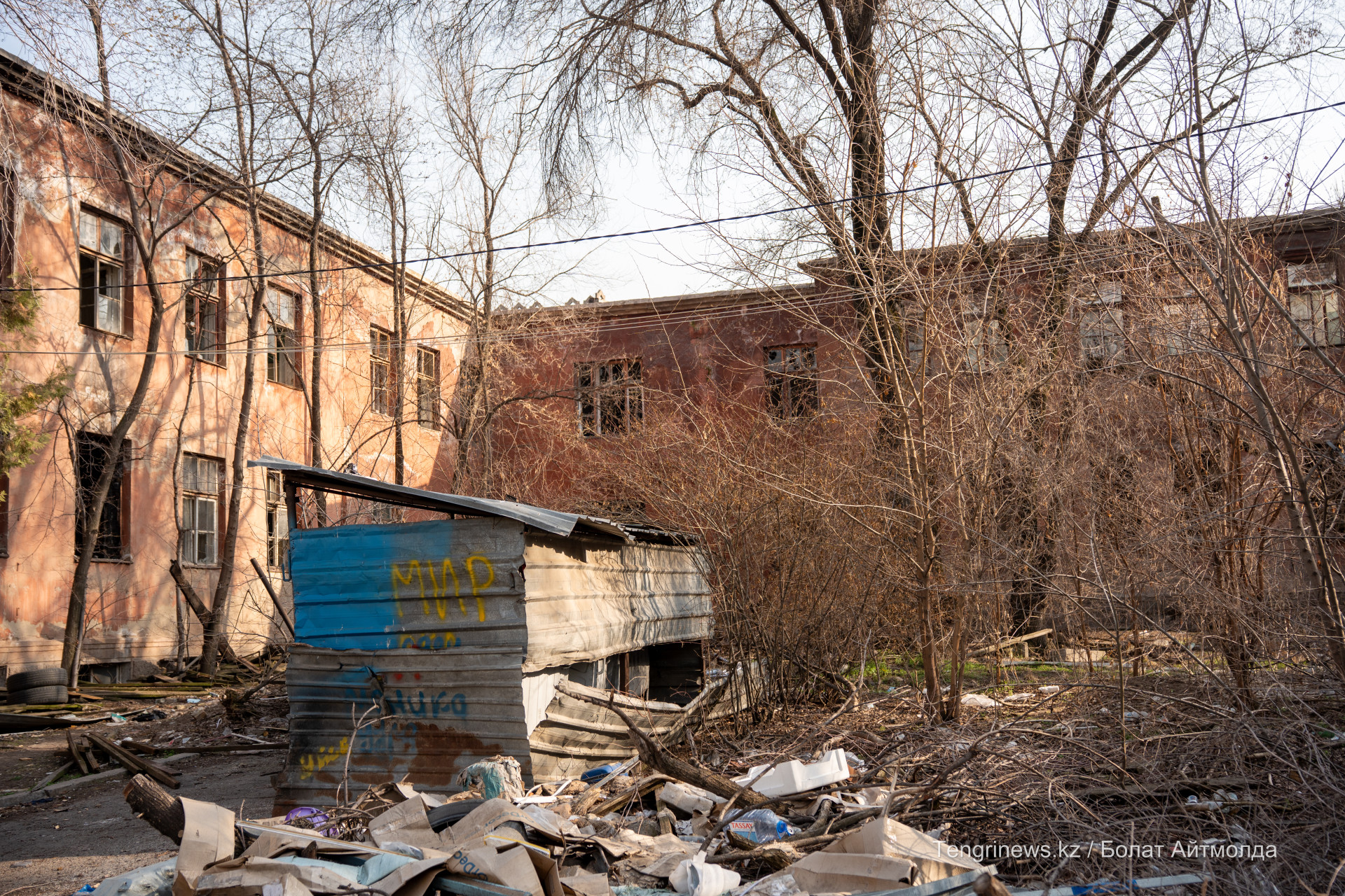Горы строительного и бытового мусора на заднем дворе заброшенной больницы Турксиба