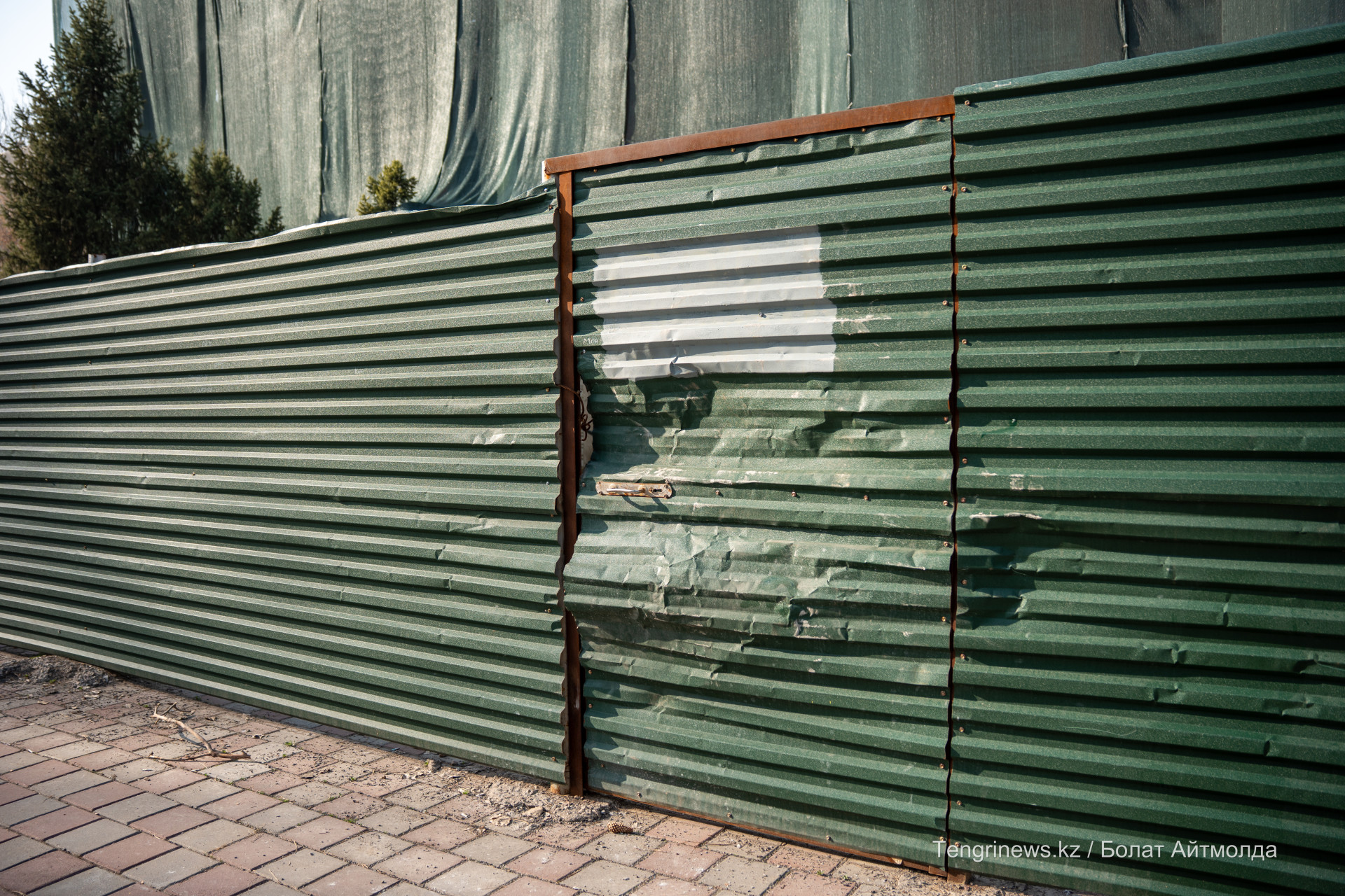 Сломанный забор вокруг территории аварийного памятника архитектуры в Алматы
