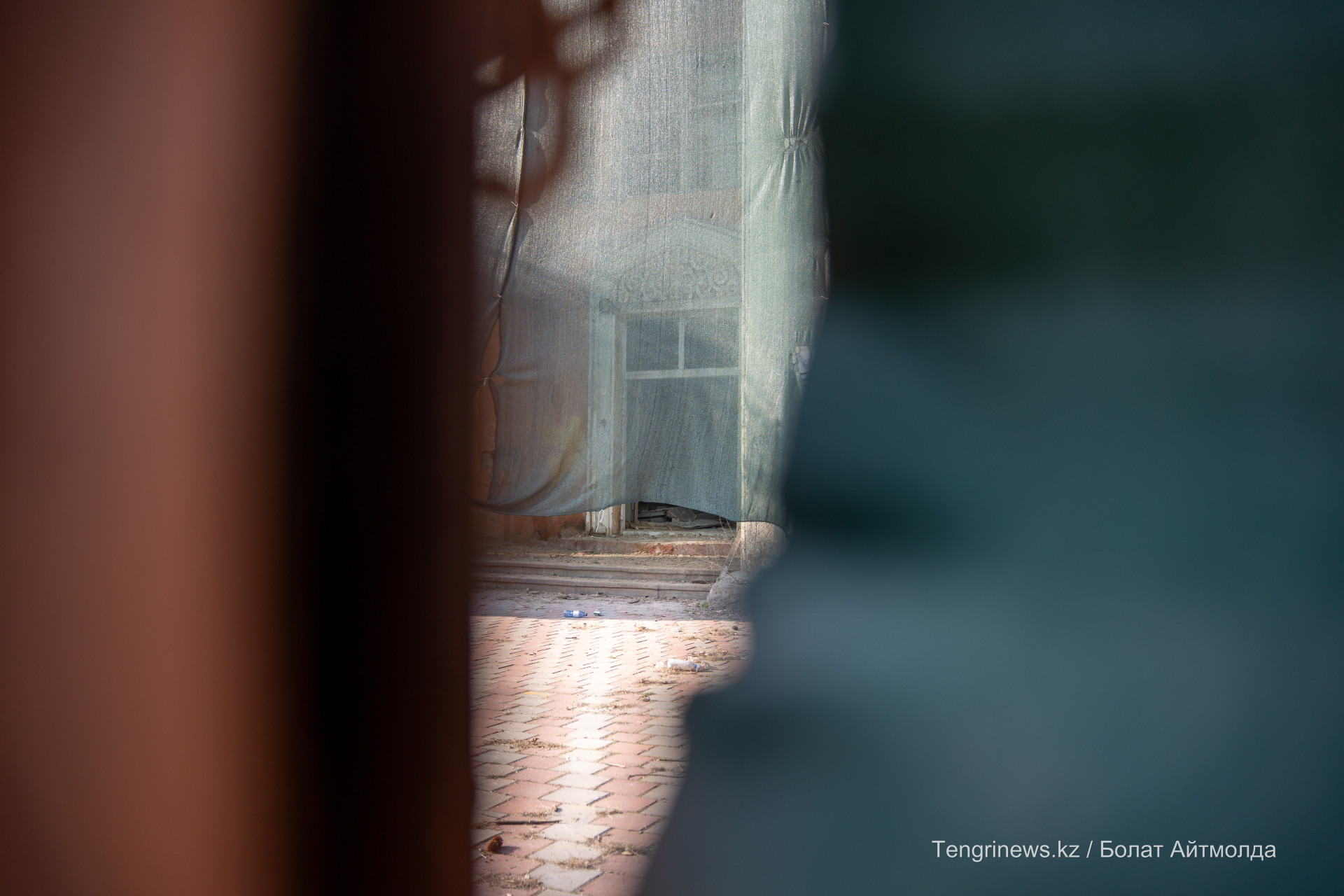 Вид на бывшую больницу Турксиба через дыру в заборе